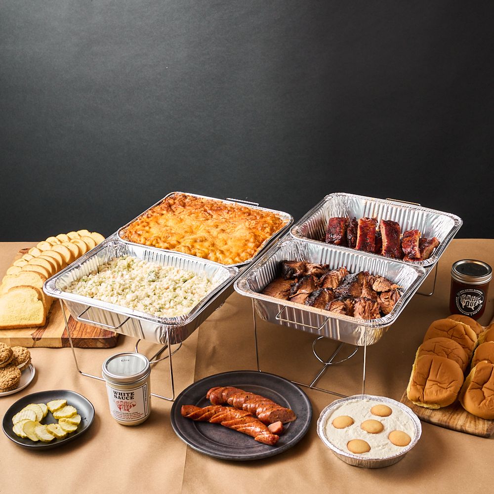 Catering spread with mac and cheese, slaw, brisket, ribs, buns and banana pudding