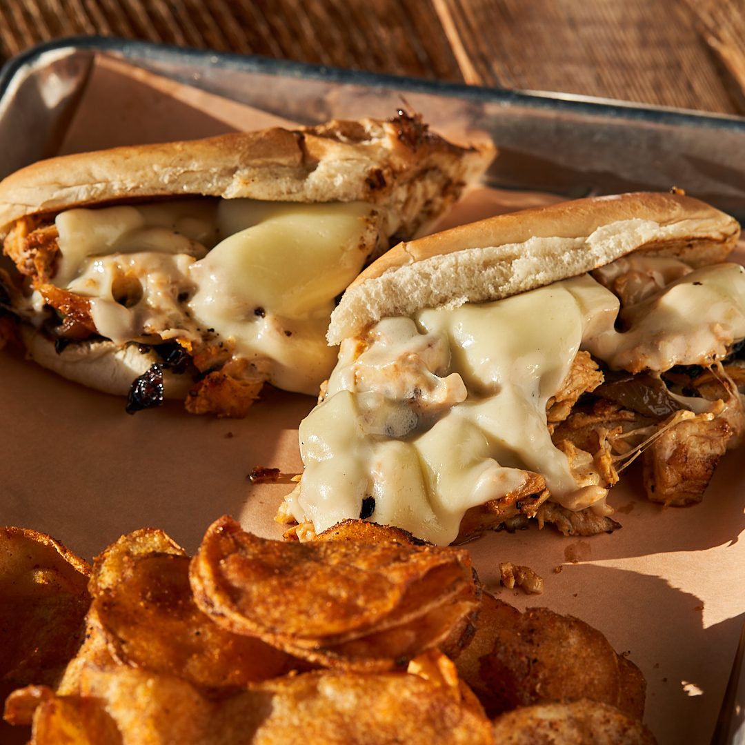 Smoked chicken Philly with melted provolone and house chips