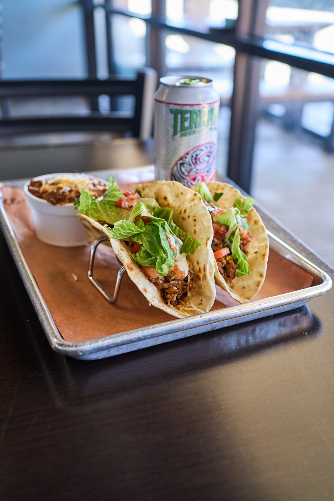 Two BBQ tacos with lettuce, tomato and cheese