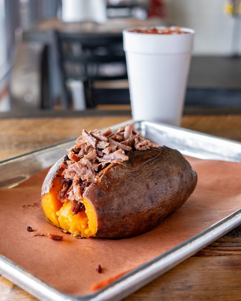 A loaded sweet potato topped with smoked brisket